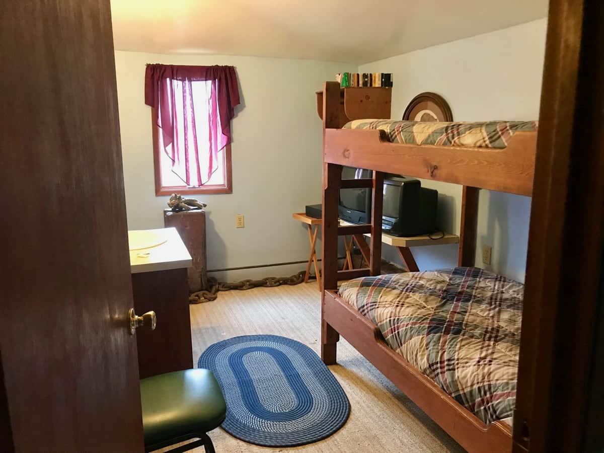 Room with two bunks beds, tv and sink
