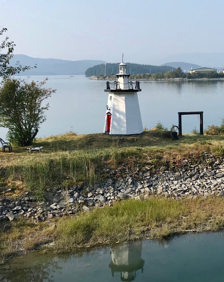 Daytime view of lighthouse and bay with reflection